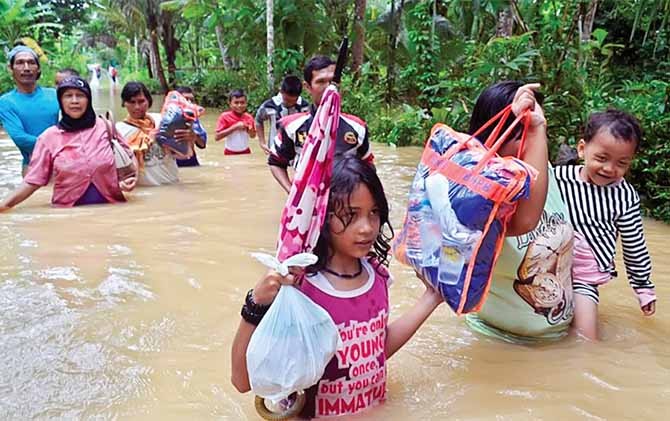 PULANG : Warga Bojong, Bapangsari, Bagelen, Purworejo terpaksa menerobos air yang belum surut untuk kembali ke rumah. Sebelumnya, mereka bermalam di Masjid Al Mutaqim yang dimanfaatkan sebagai tempat pengungsian sementara. - Image
