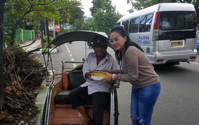 Istri Kurnia Meiga, Azizah, saat membagikan nasi kotak kepada sesama yang membutuhkan - Image