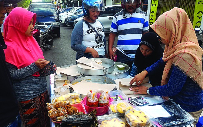 LARIS MANIS: Kurnia (kanan) bersama Paulina sibuk memotong kue talam. - Image