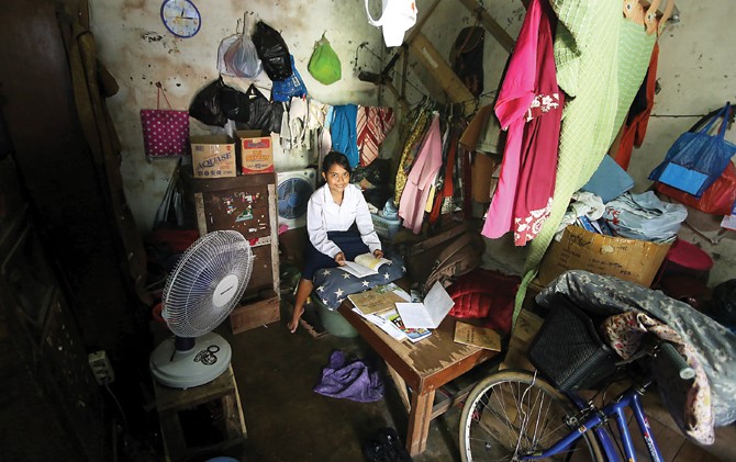 SEMANGAT MEMBARA: Linda Wijayanti belajar di rumah petak di kawasan Kapas Madya, Surabaya yang ditinggalinya bersama ibu, Soepia, dan ayah, Wiji. - Image