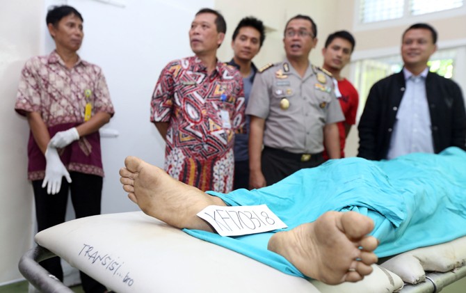TINGGAL NAMA: Direktur Reserse Kriminal Umum Polda Metro Jaya Kombespol Rudy Heriyanto Adi Nugroho (kanan) bersama Kabidhumas Polda Jatim Kombespol Frans Barung Mangera (dua dari kanan) saat mengamati jenazah SFL di kamar mayat RSUD dr Soetomo kemarin. SF - Image