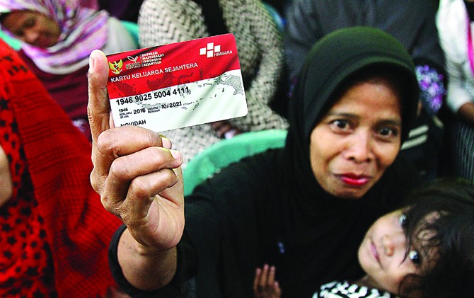 SEMRINGAH: Warga menunjukkan kartu keluarga sejahtera yang diterima dari Kementerian Sosial. - Image