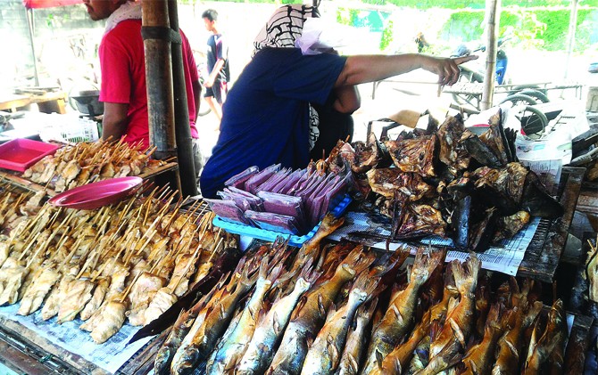 LARIS: Pedagang sibuk melayani pembeli ikan asap. - Image