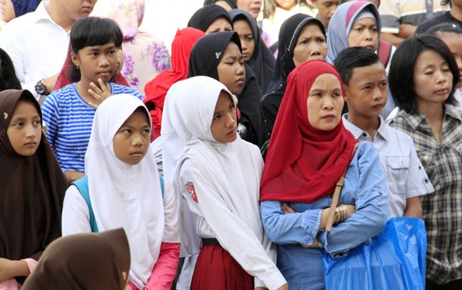 Orangtua dan anaknya mengantre saat mendaftarkan anaknya sekolah di SMPN 3 Seiharapan, Sekupang, Senin (5/6). - Image
