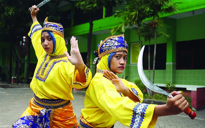 RAJIN BERLATIH: Akira Devy Kauri (kiri) dan Lailatul Khusna Girindra me nunjukkan salah satu jurus pencak silat andalan mereka. - Image