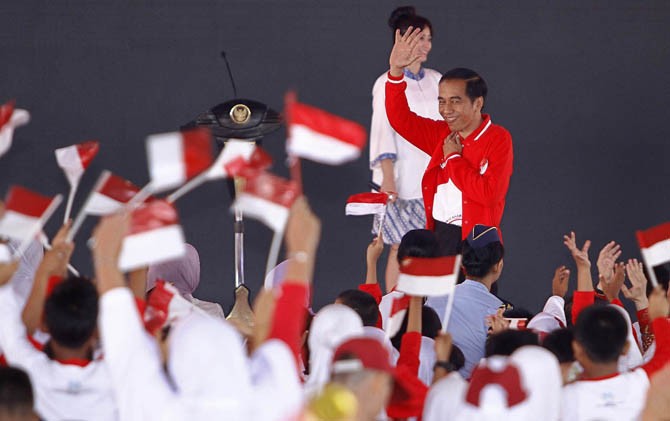 Presiden Jokowi melambaikan tangan kepada ribuan anak-anak yang hadir di acara Hari Anak Nasional 2017 di Gedung Daerah Provinsi Riau, Minggu (23/7) lalu. - Image