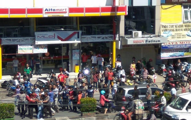 Suasana Alfamart Gajah Mada, Pontianak, ketika terjadi keributan, Kamis (20/7). Terlihat polisi sedang mengamankan Dioni. - Image