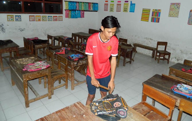 salah satu perwakilan anak didik memaku tas di atas meja di SDN 1 Dompyong Wetan, Kabupaten Cirebon, Minggu malam (16/7). Meja itu menjadi pilihan peserta didik baru. - Image