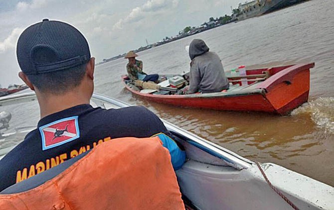 Anggota Dit Polair Polda Kalbar menggiring dua warga yang menyetrum ikan ke Marmit Patroli Tanjung Pulau. - Image