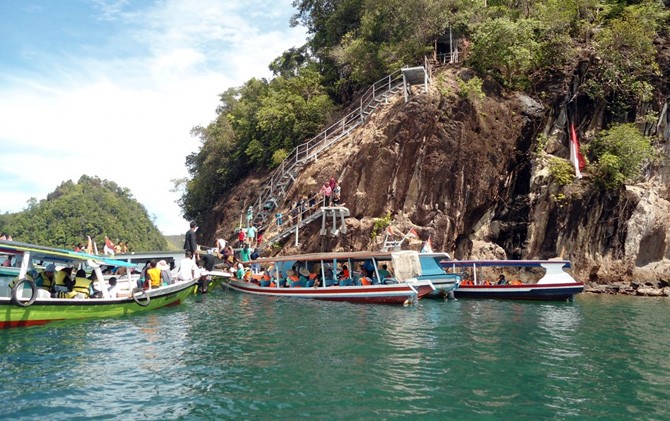 Para wisatawan menunggu giliran untuk melakukan cliff jumping di Pulau Sironjong di kawasan wisata Mandeh beberapa waktu lalu. - Image