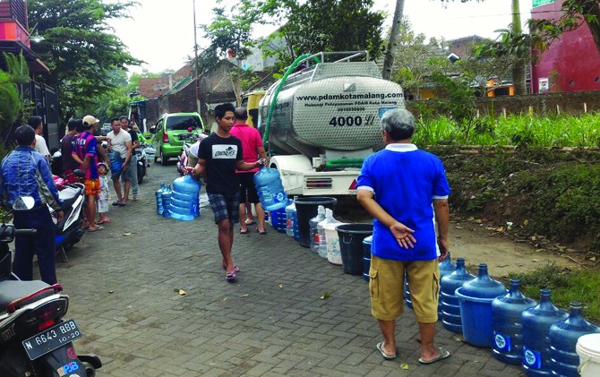 LANGKA: Warga Perumahan City Side Residence Malang mengantre untuk mendapatkan jatah air dari PDAM Kota Malang. - Image