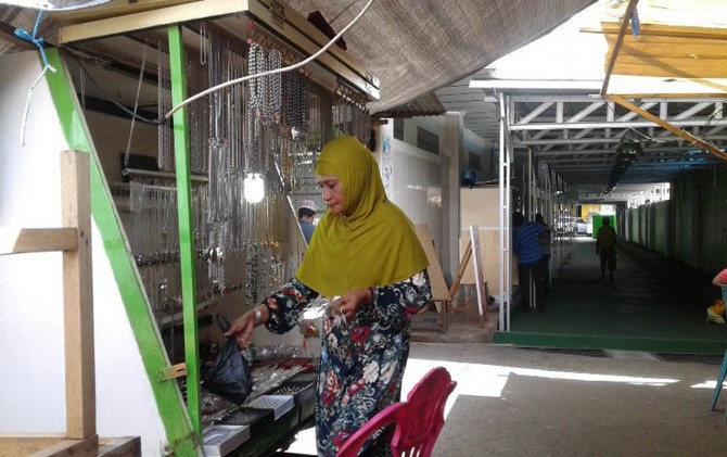 Arfiah Hakim pedagang besi putih yang biasa mangkal di kawasan samping Gloria Minimarket Ternate Tengah saat menunggu pembeli di lapak sederhananya kemarin - Image
