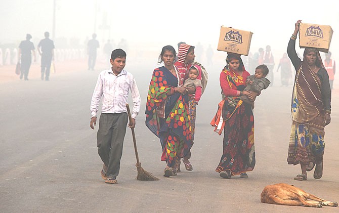 TERPAKSA: Warga India beraktivitas di luar rumah meski kabut asap memenuhi seluruh penjuru New Delhi. - Image