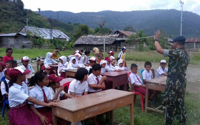 Murid sekolah Satu Atap Sedoa terpaksa belajar di tanah lapang karena tenda belajarnya roboh diterpa angin puting beliung - Image