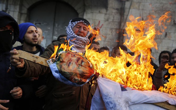 KERAS: Pemrotes Palestina membakar patung Presiden AS Donald Trump, di kota Nablus, Tepi Barat, Selasa (7/12). - Image