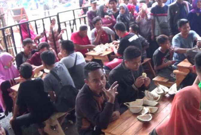 Pengunjung makan terburu-buru karena waktu dibatasi akibat membludaknya ribuan pengunjung yang harus bergantian. - Image