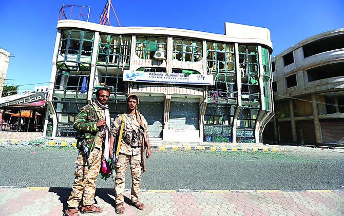 KONFLIK: Dua tentara Houthi di depan gedung rusak di Sanaa (6/12). - Image