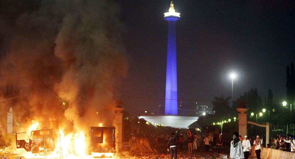Mobil terbakar saat bentok pendemo dengan aparat di depan Istana Merdeka di Jakarta, Jumat (4/11). - Image