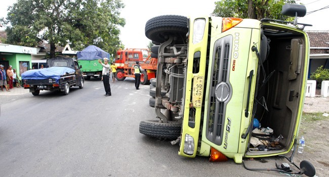 BERANTAKAN: Truk kontainer L 9040 UJ terguling Senin (6/11) di Jalan Raya Lajuk, Porong, Sidoarjo. - Image