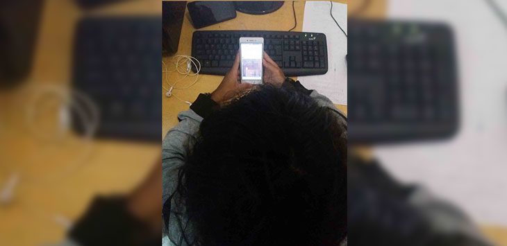 Salah seorang warga saat menonton video yang memperlihatkan sejumlah warga saat mengintogasi pelaku yang diduga sedang mesum. - Image
