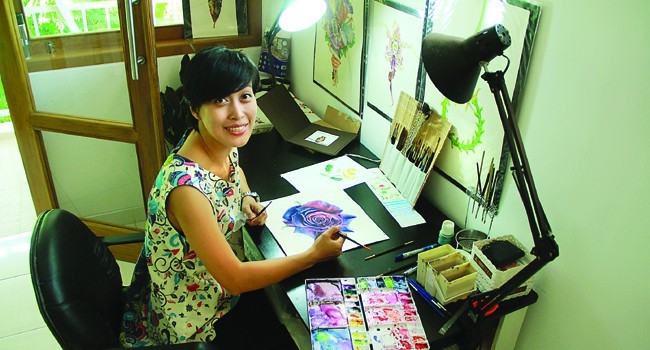 DARI HOBI: Eunike Nugroho di studio lukisnya di Jogja. Foto kanan, botol- botol wine produk Spanyol dengan gambar karya Eunike pada labelnya. - Image