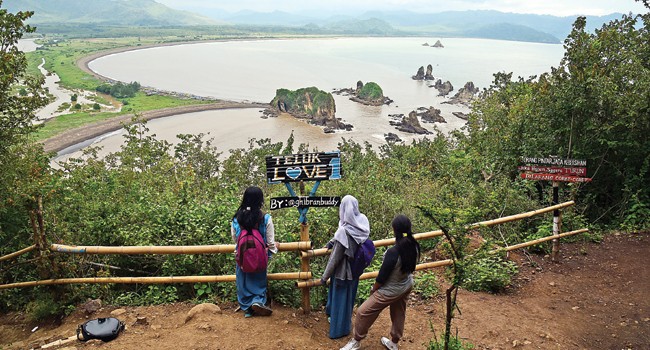 FAVORIT PENGUNJUNG: Meski musim hujan dan akses jalan yang susah, Teluk Love di Pantai Payangan, Kecamatan Ambulu, Jember ini masih menjadi jujukan anak muda berwisata. - Image