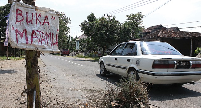 AKSI PROTES: Warga menanam pisang di samping jalan berlubang di Jalan Ponorogo–Magetan, tepatnya di Desa Gupolo, Babadan, Ponorogo. - Image