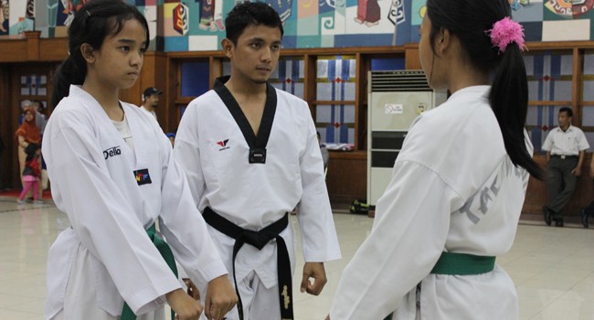 PULUHAN MEDALI: Angga Syafrianto (tengah) beraksi di sela-sela mengajar anak didiknya untuk persiapan kenaikan tingkat. - Image