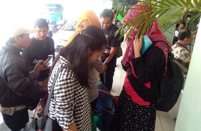 Sembilan orang TKI asal Jateng yang sempat tertahan di Malaka, Malaysia menghindari wartawan, Sabtu (31/3). - Image