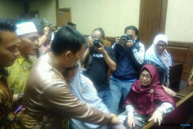 Bupati Bener Meriah Nonaktif, Ahmadi (berbaju cokelat) dipeluk sang ibu ketika menjalani sidang di Jakarta, Senin (3/12). - Image
