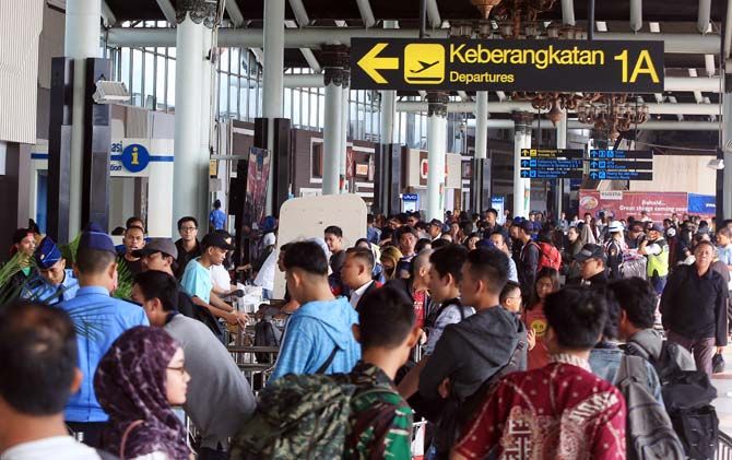 Ilustrasi: petugas keamanan bandara melayani penumpang sebelum masuk ruang tunggu. - Image