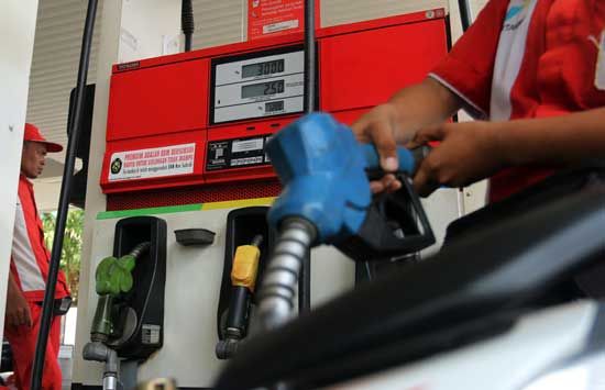 Ilustrasi petugas SPBU Pertamina tengah melayani pelanggan - Image