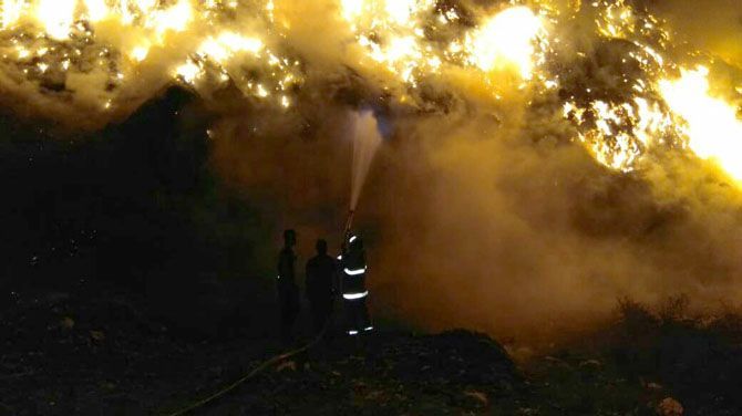 MEMADAMKAN: Seorang petugas pemadam kebakaran tengah berusaha memadamkan api di TPA Putri Cempo, Solo, Sabtu (20/10). - Image