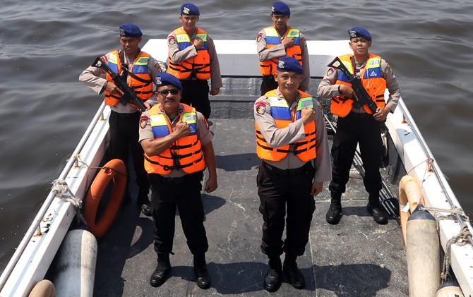 Kasat Polair Polres Kepulauan Seribu AKP Zaroki (kanan depan) bersama jajarannya berfoto usai menggelar kegiatan patroli rutin sambil membersihkan sampah di batas wilayah Kepulauan Seribu, Jakarta, Selasa (1/5). - Image