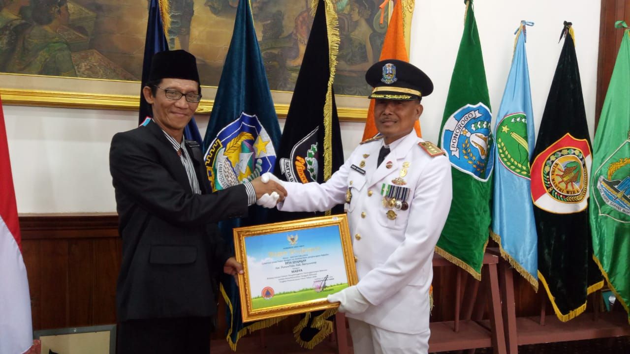 Kepala BPBD Pemprov Jatim Suban Wahyudiono memberikan penghargaan Kepala Pelaksana Banyuwangi Fajar Suasana - Image