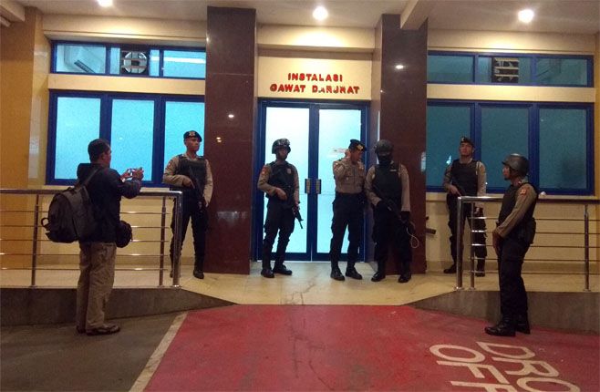 DIJAGA KETAT: Pintu masuk IGD RS Mitra Plumbon Cirebon dijaga ketat anggota kepolisian bersenjata lengkap, Sabtu (25/8) dini hari. - Image