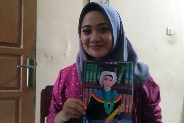 KORBAN JIWA: Hestina Junita Tsani, memegang foto bergambar kakaknya, Almarhumah Avina Junita Fitri, Selasa (25/12). - Image