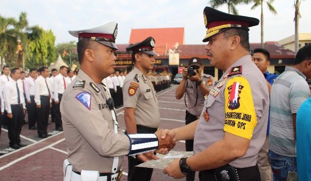 Wakapolda Riau, Brigjen Pol Ermi Widyatno (kanan) memberikan penghargaan kepada personil Satlantas Polresta Pekanbaru, Aiptu Bella (kiri) di halaman Mapolda Riau, Kamis (8/2) pagi. Attachments area - Image