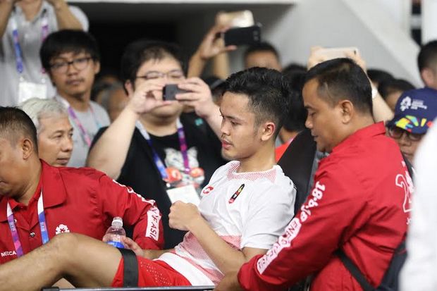 Anthony Sinisuka Ginting ditandu keluar arena setelah mengalami cedera di pertandingan pertama babak final beregu Asian Games 2018. - Image