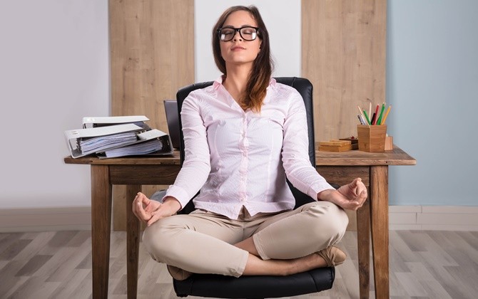 Gerakan yoga sederhana ternyata bisa dilakukan di atas kursi ketika berada di kantor. - Image