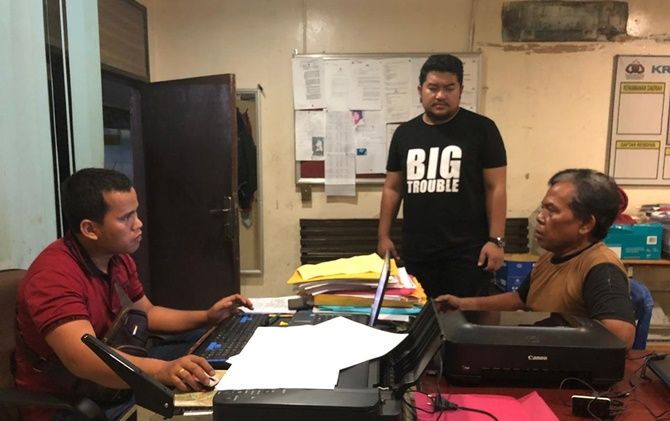 SP (mengenakan kaos coklat) saat diperiksa penyidik Polsek Mandau, Bengkalis, Riau, karena diduga telah melakukan penistaan agama Islam di akun Facebooknya. - Image