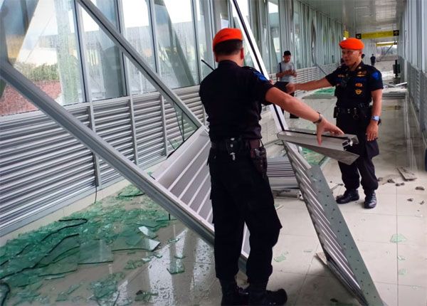 HUJAN DERAS: Petugas menyingkirkan bagian rangka skybridge yang roboh karena hujan deras disertai angin kencang, Jumat (11/1). - Image