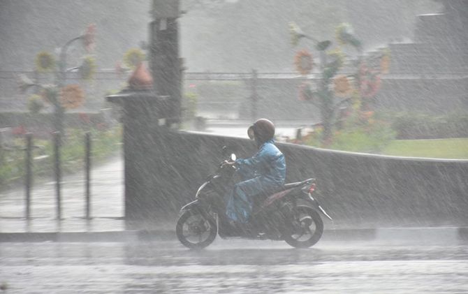 Seorang pengendara motor menerjang hujan deras yang mengguyur kawasan Balai Kota Malang, Selasa (23/10) - Image