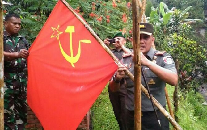 Komandan Kodim 1309 Manado Letkol Arm Toar Pioh menemukan bendera bergambar palu arit, yang diketahui merupakan lambang PKI, di Desa Susulan, Tombulu, Minahasa. - Image