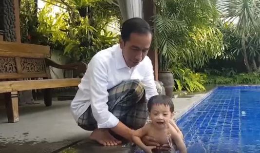 Jokowi saat bermain dengan cucu pertamanya Jan Ethes, di kediamannya di Solo, Jawa Tengah. - Image