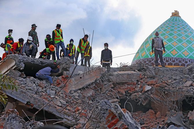 Petugas gabungan ketika mengevakuasi beberapa korban yang tertimbun bangunan yang roboh beberapa waktu lalu. - Image