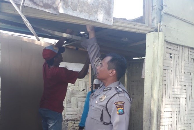 Personel Polsek Medan Barat saat membantu memperbaiki rumah penyandang diasabilitas di Medan, Jumat (26/1). - Image