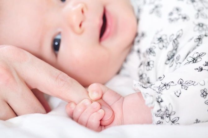 Ilustrasi bayi melakukan gerakan refleks sentuhan. - Image