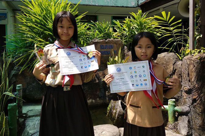 Noriko Khang (kiri) dan Yuriko Khang menunjukkan medali emas WMI yang diraihnya di Korsel. - Image