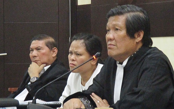 Dari kiri: Matheus Mangentang, Ernawaty Simbolon, dan pengacara Tommy Sihotang mendengar keterangan dari saksi fakta saat persidangan. - Image